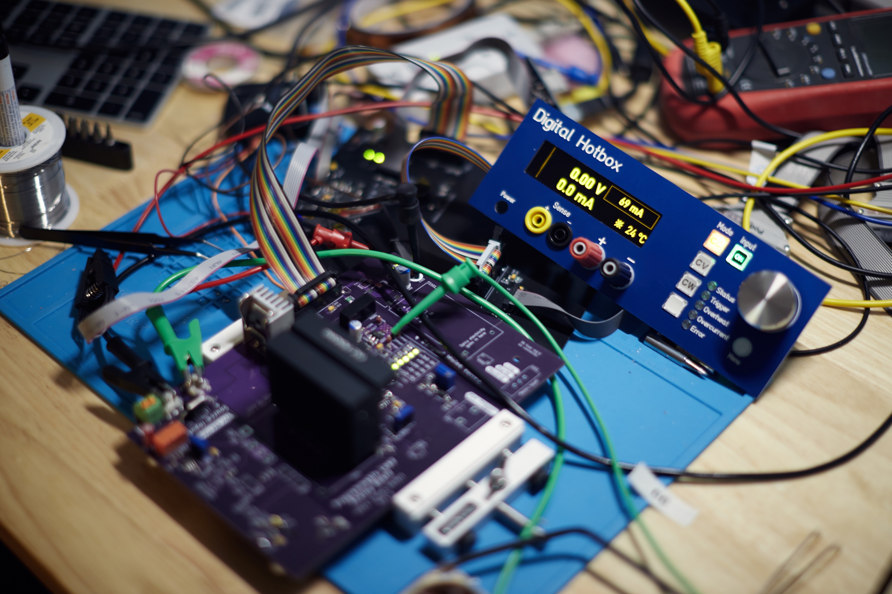 A somewhat more finished pile of programmable load boards splayed out on a workbench.